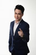 Professional headshot of Asian man in navy suit with confident smile